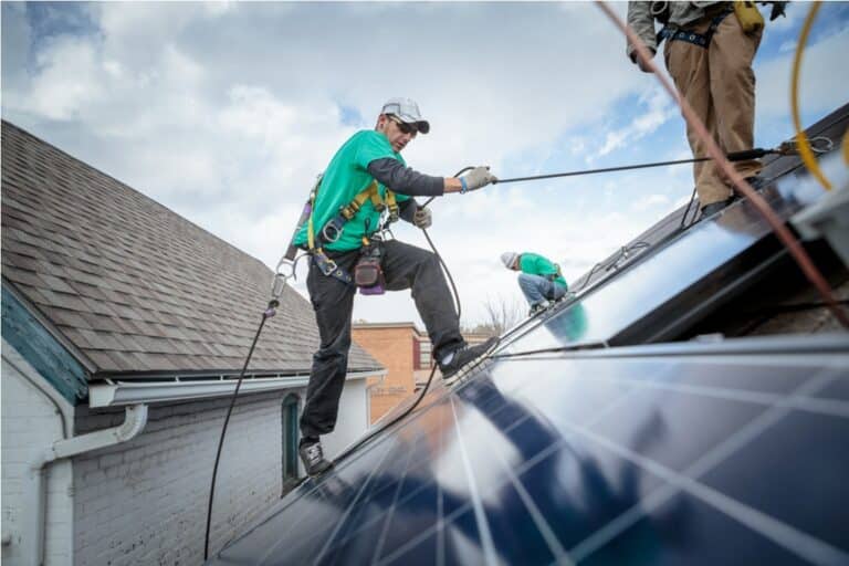 construction crew installing solar panels on a house