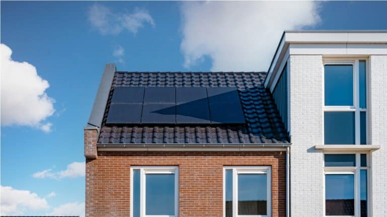 newly build houses with solar panels attached on the roof against a sunny sky