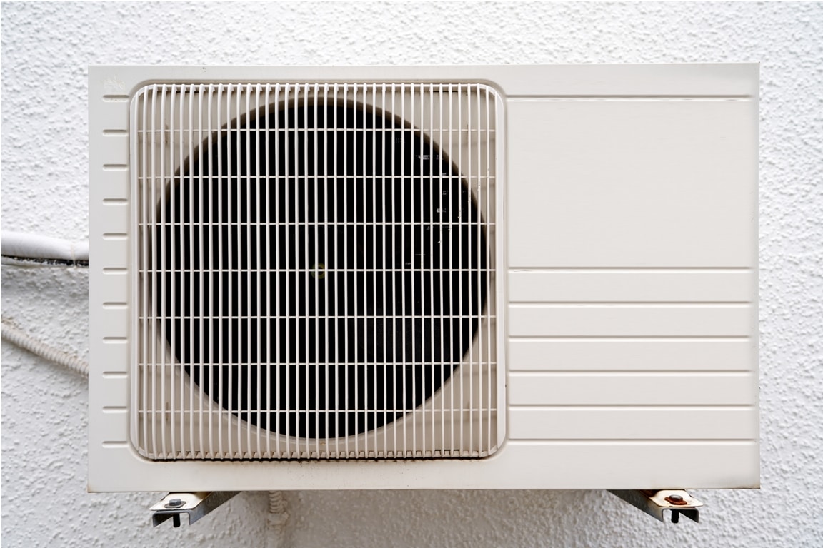 white air conditioner hangs on a wall. close up